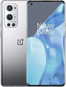 OnePlus 9 Pro smartphone in emerald green. The phone has a large, edge-to-edge display and a sleek, minimalist design. The text "Never Settle" is printed on the back of the phone.